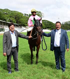 Star Symphony (B R Kumar up) winner of the MYSORE MILLION, being led in by trainer Pradeep Annaiah on Saturday races at Mysore.